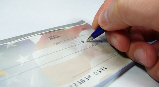 Picture of someone writing a check
